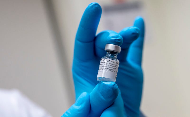 Soldier holding a vial of COVID-19 vaccine