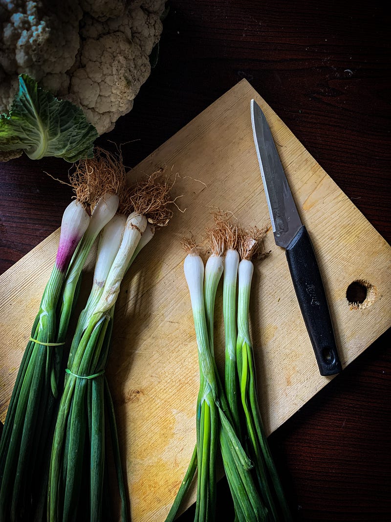 Spring onions being washed, symbolizing attention to detail.